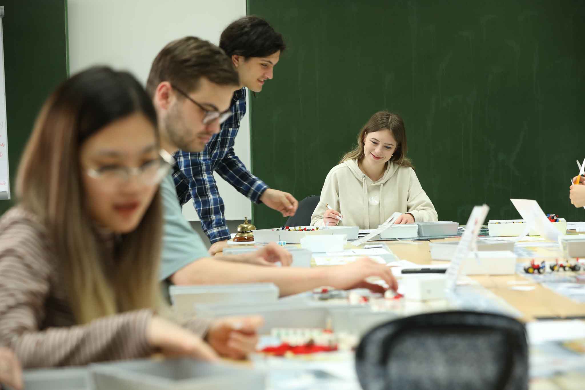 4 Studierende in einem Lehrsaal arbeiten an einem Projekt
