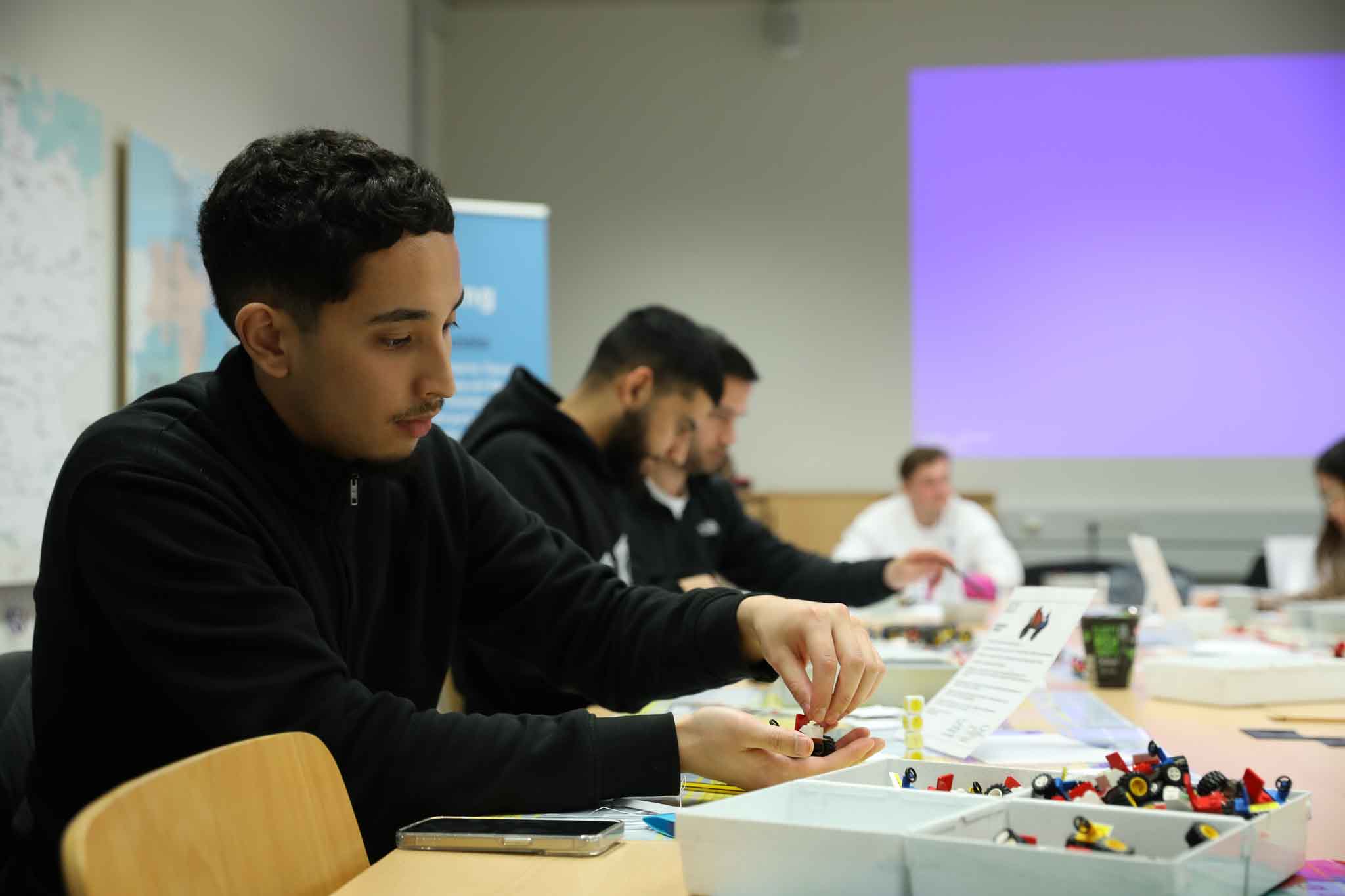 Ein Student arbeitet mit Legos an einem Projekt.